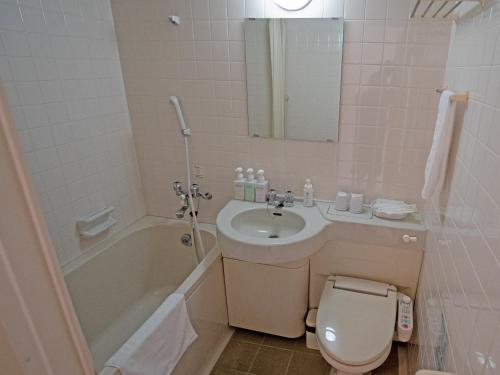 a bathroom with a sink and a toilet and a tub at 真田昌幸-幸村父子の隠れ宿 紀伊見荘 in Hashimoto