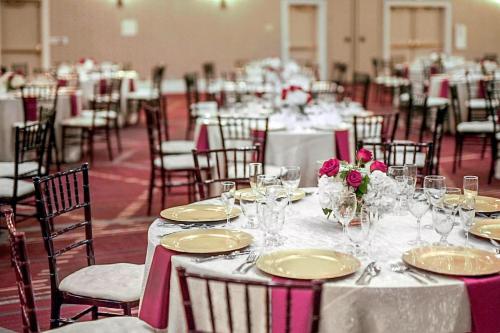 a room filled with tables and chairs with plates and flowers at Ann Arbor Marriott Ypsilanti at Eagle Crest in Ann Arbor