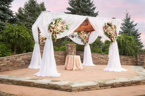 a wedding arch with flowers and a table at Ann Arbor Marriott Ypsilanti at Eagle Crest in Ann Arbor