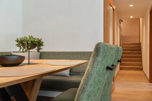 a dining room with a wooden table and green chairs at Meerberg in Pertisau