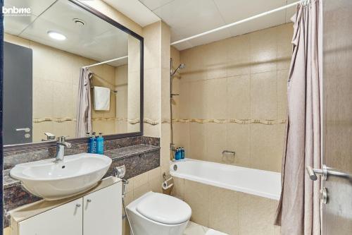 a bathroom with a sink and a toilet and a tub at bnbmehomes - Cozy modern JLT flat next to metro - 405 in Dubai