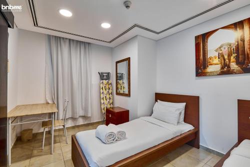 1 dormitorio con 1 cama con 2 toallas en bnbmehomes - Cozy modern JLT flat next to metro - 405, en Dubái