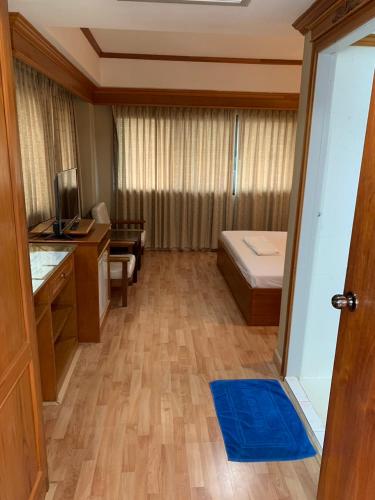 a room with a room with a desk and a bed at Imperial Sakon Hotel in Sakon Nakhon