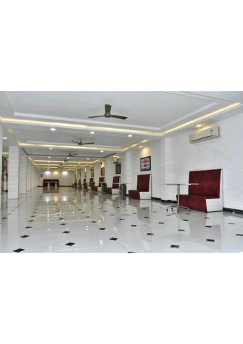 an empty hall with chairs and tables in a building at Gods County Hotels & Resorts in Tarapith