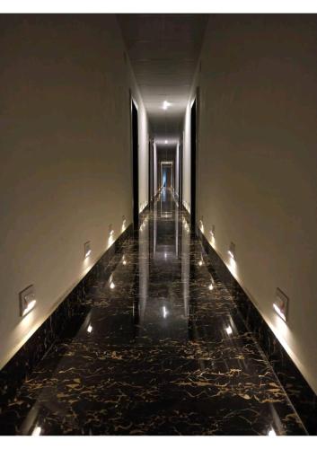 an empty hallway with lights on the floor at Gods County Hotels & Resorts in Tarapith