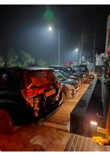 a row of cars parked in a parking lot at night at Gods County Hotels & Resorts in Tarapith