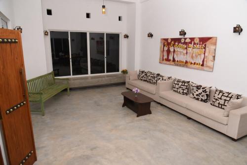 a living room with two couches and a table at Everdew Kandy Rooms in Kandy