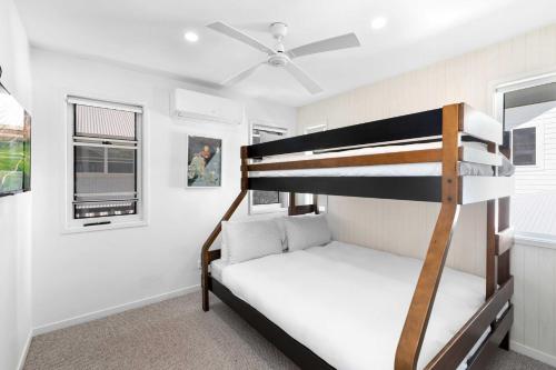 a small bedroom with a bunk bed and a ceiling fan at La Mer in Marcoola in Marcoola
