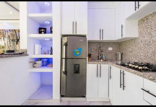 eine Küche mit weißen Schränken und einem Kühlschrank in der Unterkunft Skyline tower TTB in San Cristóbal