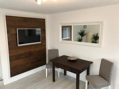 a dining room with a table and a television on a wall at Wohnung mit eigenem Zugang in Hochdorf