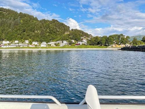 a boat on a body of water with houses at 12 person holiday home in Selje-By Traum in Selje