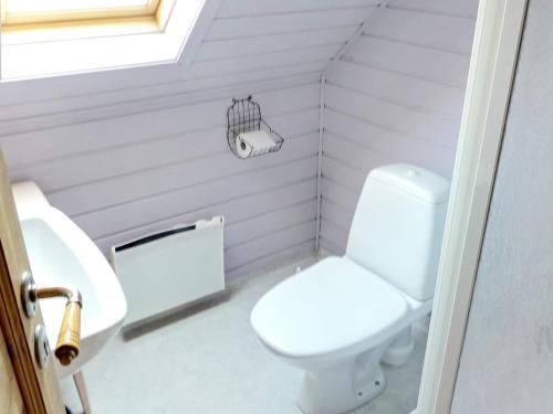 uma casa de banho com um WC branco e um lavatório. em Holiday home Selje III em Selje
