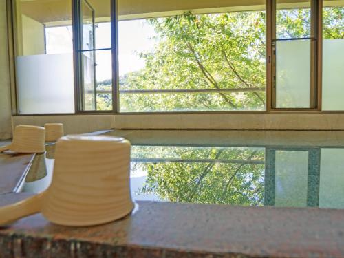 a room with a table with chairs and a large window at 真田昌幸-幸村父子の隠れ宿 紀伊見荘 in Hashimoto