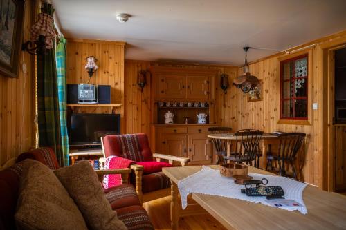 ein Wohnzimmer mit einem Tisch und Stühlen in der Unterkunft Houmbgaarden in Røros