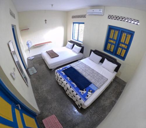 1 dormitorio con 2 camas en una habitación en Sendangarum Village Guest House Jogja, 