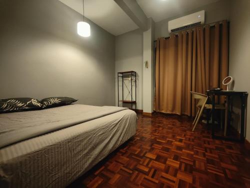 een slaapkamer met een bed en een houten vloer bij The Jewel with FREE WiFi and Box TV in Bentong