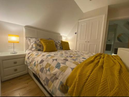 a bedroom with a bed with a yellow comforter at The Cotswold Stowaway, Perfect Luxurious Retreat! in Stow on the Wold