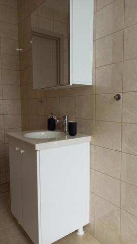 W łazience znajduje się biała umywalka i lustro. w obiekcie Apartmany Paradiso Shekvetili w mieście Shekhvetili