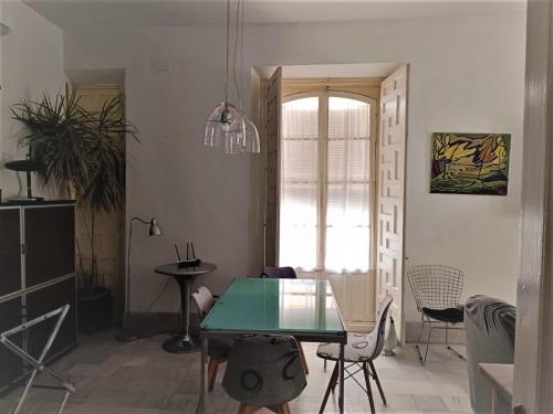 a dining room with a green table and chairs at Apartamento Santa Cruz Casco Antiguo con Terraza in Seville
