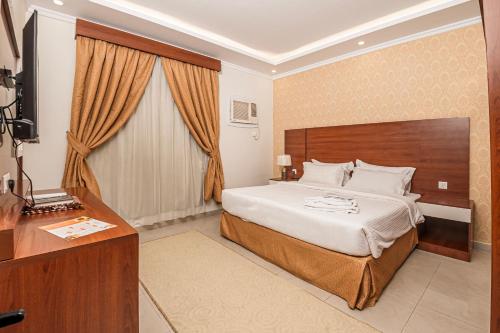 a hotel room with a large bed and a desk at فندق غالية احد in Al Madinah