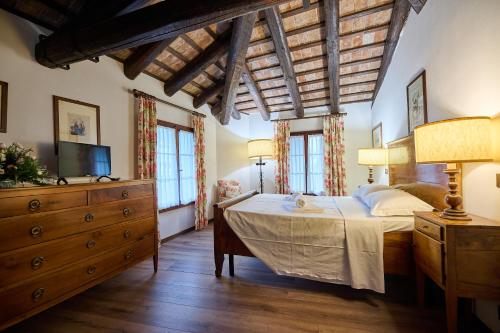 um quarto com uma cama, uma cómoda e janelas em Foresteria Castello Formentini em San Floriano del Cóllio