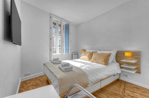 une chambre blanche avec un lit et une fenêtre dans l'établissement Don Capitolium - A 2 pas de la place du Capitole, à Toulouse