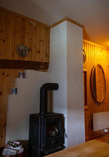a stove in a kitchen with wooden walls at Houmbgaarden in Røros
