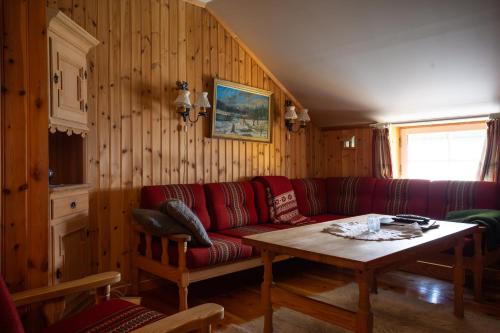 a living room with a red couch and a table at Houmbgaarden in Røros