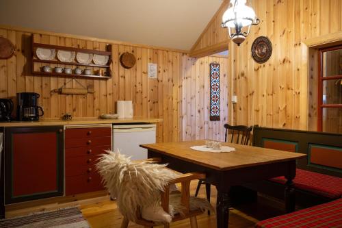 a kitchen with wooden walls and a wooden table with chairs at Houmbgaarden in Røros