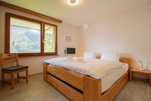 a bedroom with a large bed and a window at Sillur 2 - Apartment in Innerarosa in Arosa