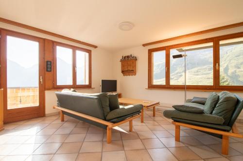 a living room with two chairs and a television at Sillur 2 - Apartment in Innerarosa in Arosa