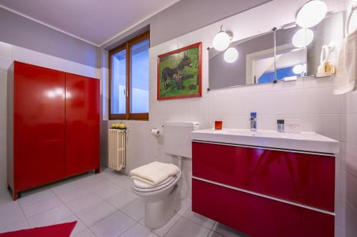 a bathroom with a toilet and a sink and a red cabinet at Villa Paola Tremezzo in Tremezzo