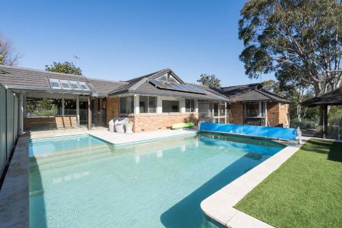 a swimming pool in the backyard of a house at 'Poolside Haven' Your Mount Eliza Family Getaway in Melbourne