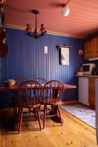 a table and chairs in a kitchen with blue walls at Houmbgaarden in Røros