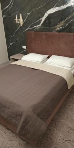 a bed with two pillows on top of it at Mon Ami Hotel in Ivano-Frankivsʼk