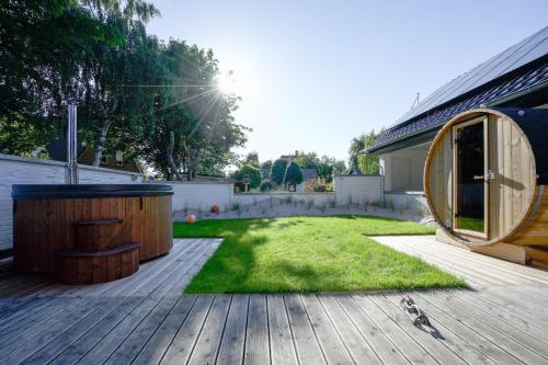 a backyard with a wooden deck with a gazebo at Super-Cottage Nordstrand in Nordstrand