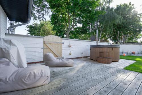 a patio with a wooden deck with a table at Super-Cottage Nordstrand in Nordstrand