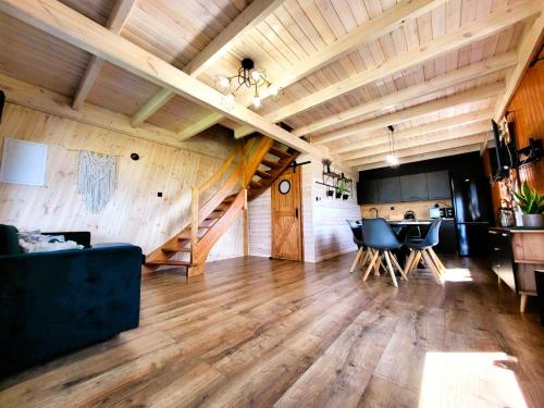 uma ampla sala de estar com tectos em madeira e uma escadaria em Domki Lawendowy Zakątek em Boszkowo