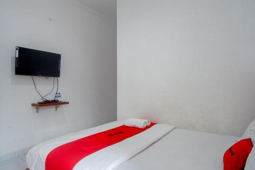 a bedroom with a bed with a flat screen tv at RedDoorz near Alun Alun Wonosobo 2 in Wonosobo