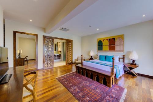 a bedroom with a bed and a living room at Cinnamon Bey Beruwala in Bentota