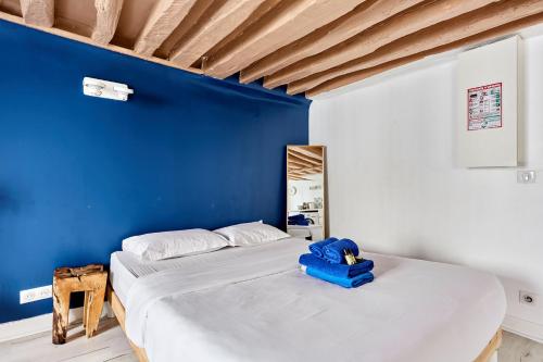 - une chambre avec un mur bleu et 2 lits dans l'établissement Rent a Room - Studio Bonne Nouvelle, à Paris