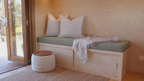 una habitación con un banco con almohadas en Southern Highlands Vineyard Cabin by Outpost, en Exeter