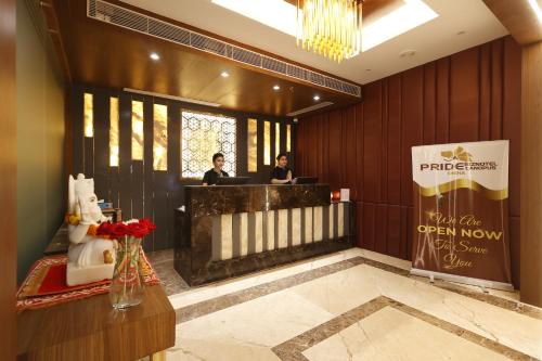 a lobby with two people on their laptops in a building at Pride Biznotel Canopus, Digha in Digha