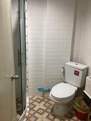 La salle de bains est pourvue d'une douche et de toilettes. dans l'établissement บ้านโนรีแมนชั่น, à Si Racha