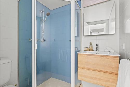 a bathroom with a shower and a sink at Sunset Swirl - A Pastel Dream by the Beach in Sydney