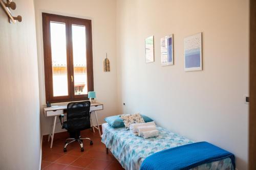 a bedroom with a bed and a desk and a window at Ferrara center - Luxury apartment in medieval area with Wi-Fi in Ferrara