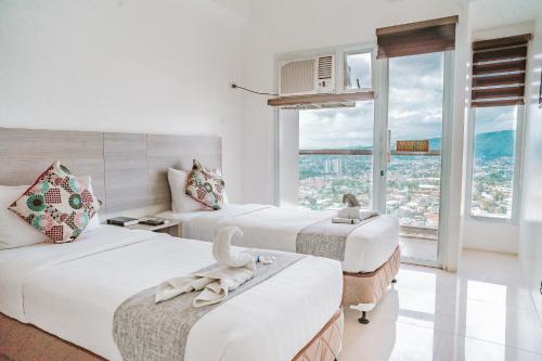 a hotel room with two beds and a window at Eon Centennial Soho Hotel in Cebu City
