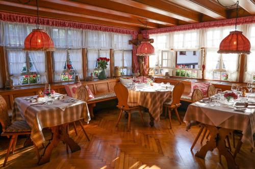 a dining room with tables and chairs and windows at Hotel-Gasthaus Goldener Engel in Glottertal