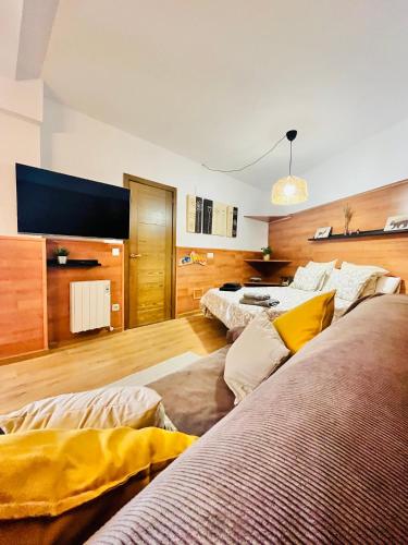 a living room with two beds and a tv at Nuevo Cosy Loft 4pax Estavar in Estavar