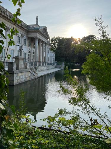 a building with a river in front of it at Centrum Konferencyjno-Apartamentowe Mrówka in Warsaw